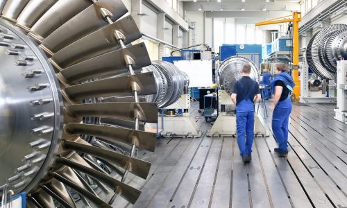 Zwei Mitarbeiter*innen eines Maschinenbauunternehmens untersuchen eine Turbine