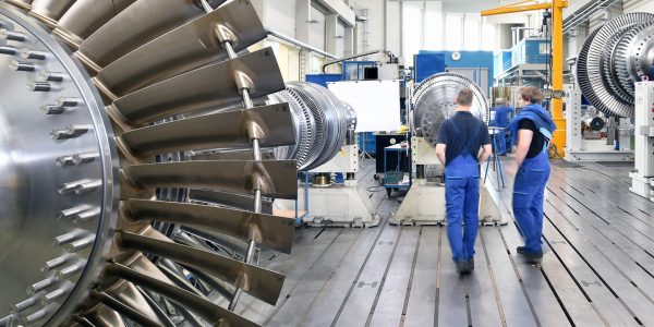 Zwei Mitarbeiter*innen eines Maschinenbauunternehmens untersuchen eine Turbine